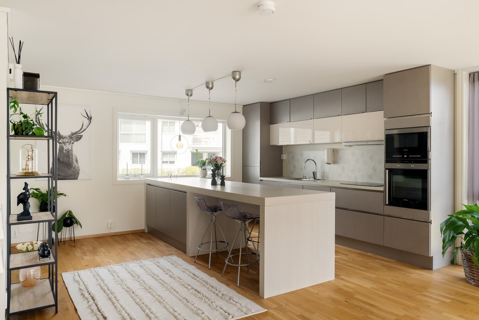 Stue/kjøkken ligger i moderne, åpen løsning på hovedplan. Nydelig innredning med kjøkkenøy og kombinert barløsning/sitteplass. Lekkert og praktisk! Galleribilde