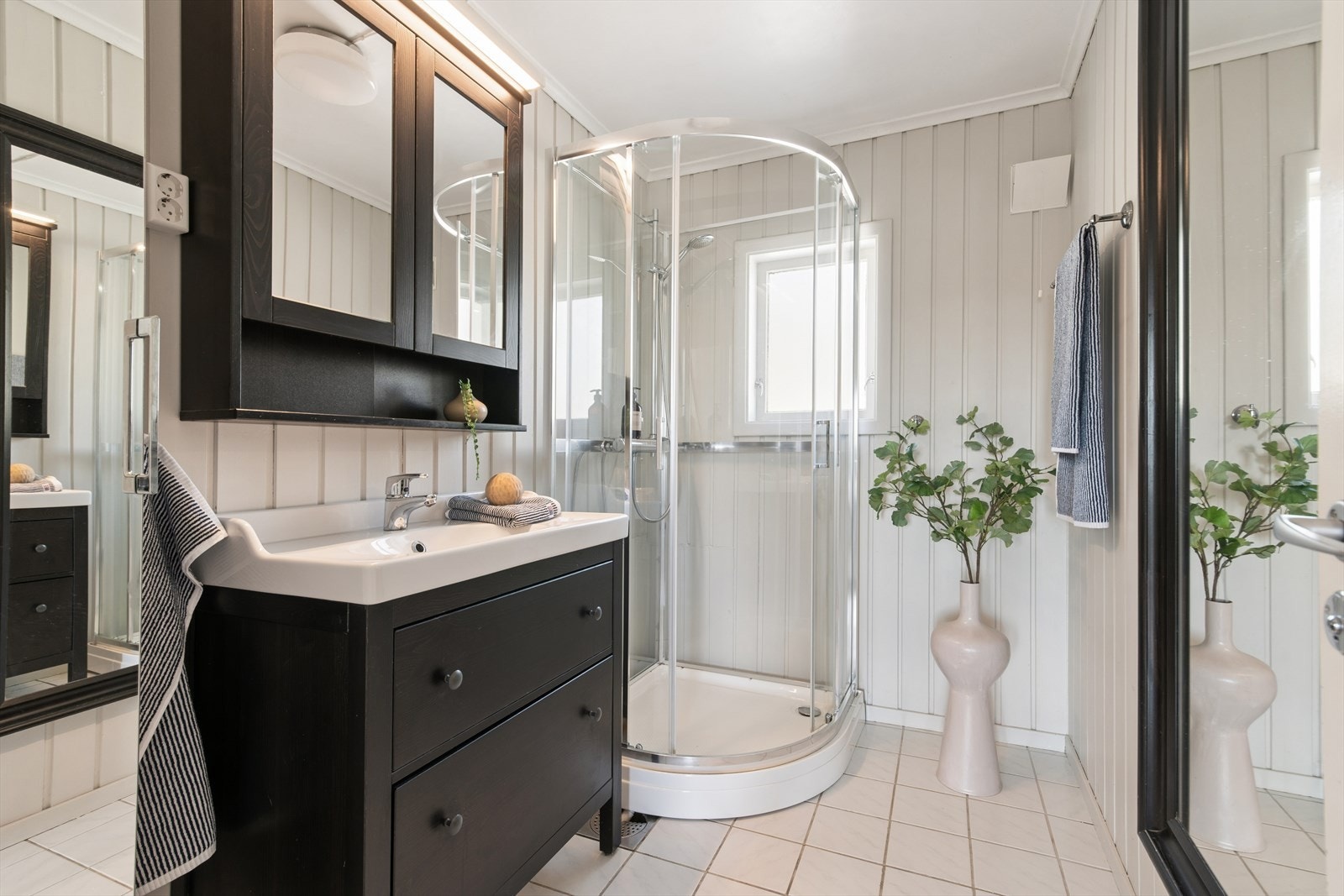 Badet i første etasje har flislagt gulv, panel på veggene og dusjkabinett. Galleribilde