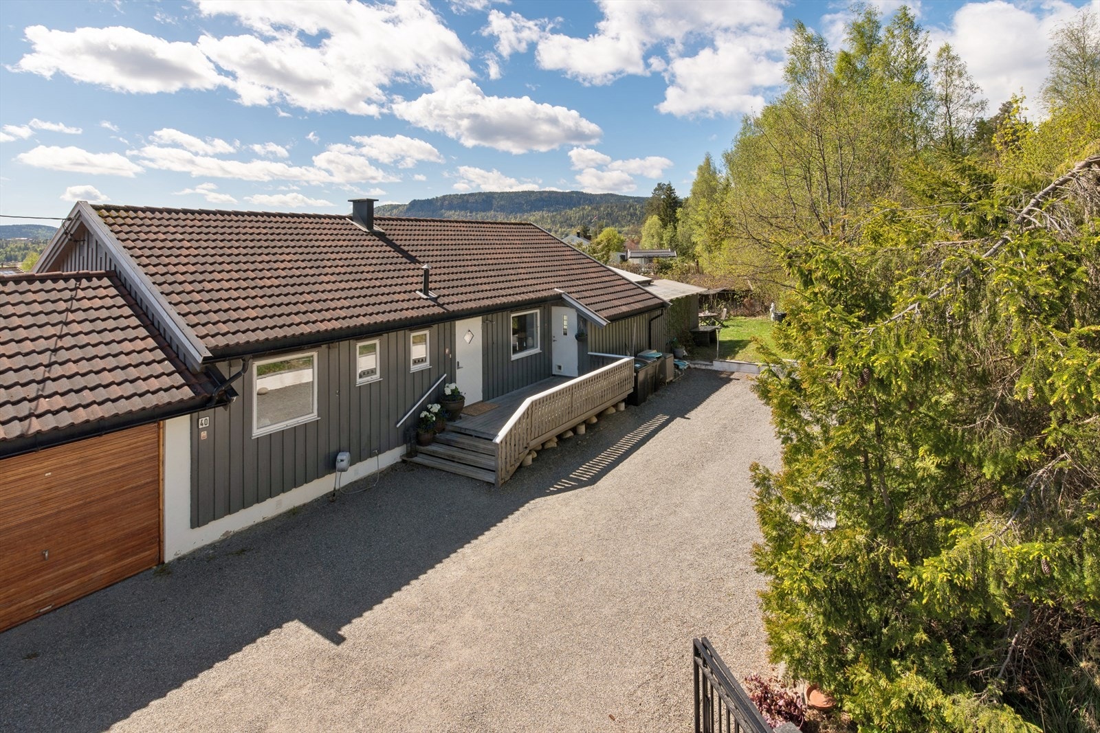Eiendommen har en romslig, gruset gårdsplass med garasje og carport. Galleribilde
