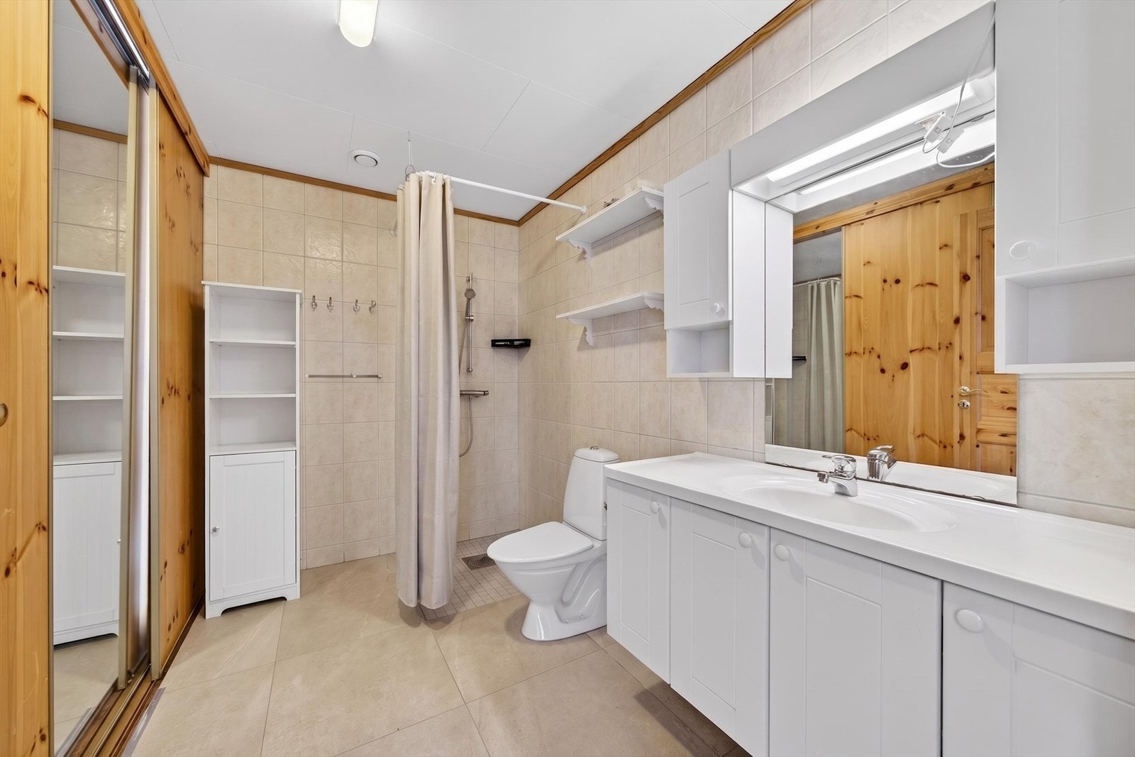 Boligen har to bad - fordelt med ett i hver etasje. Badet i 1. etasje har fliser på gulv og vegger. Innredet med baderomsinnredning, toalett og dusjløsning. Galleribilde