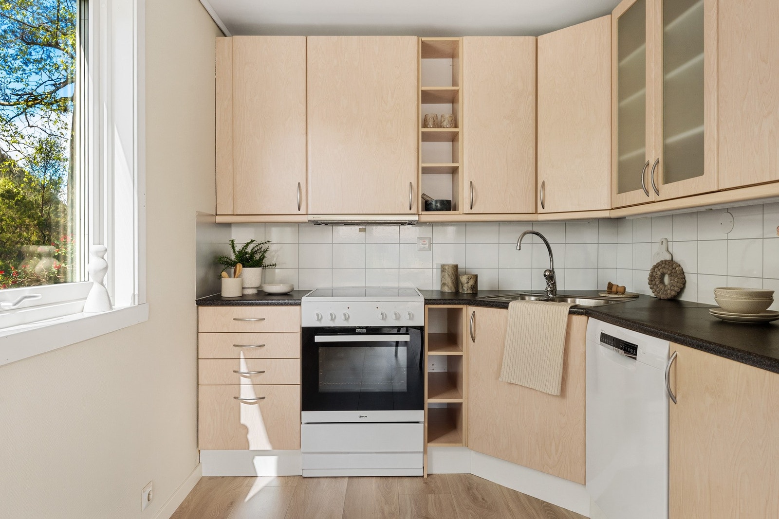 - Kjøkkeninnredning med slette fronter, laminat benkeplate, over benkeplate er det kitchenboard, stål oppvaskkum og ventilator - Galleribilde