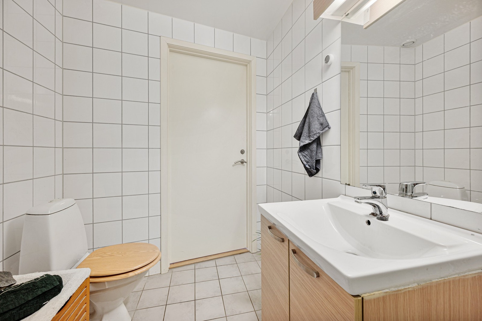 Badet er utstyrt med dusjhjørne, servantskap, mekanisk avtrekk og wc. Galleribilde