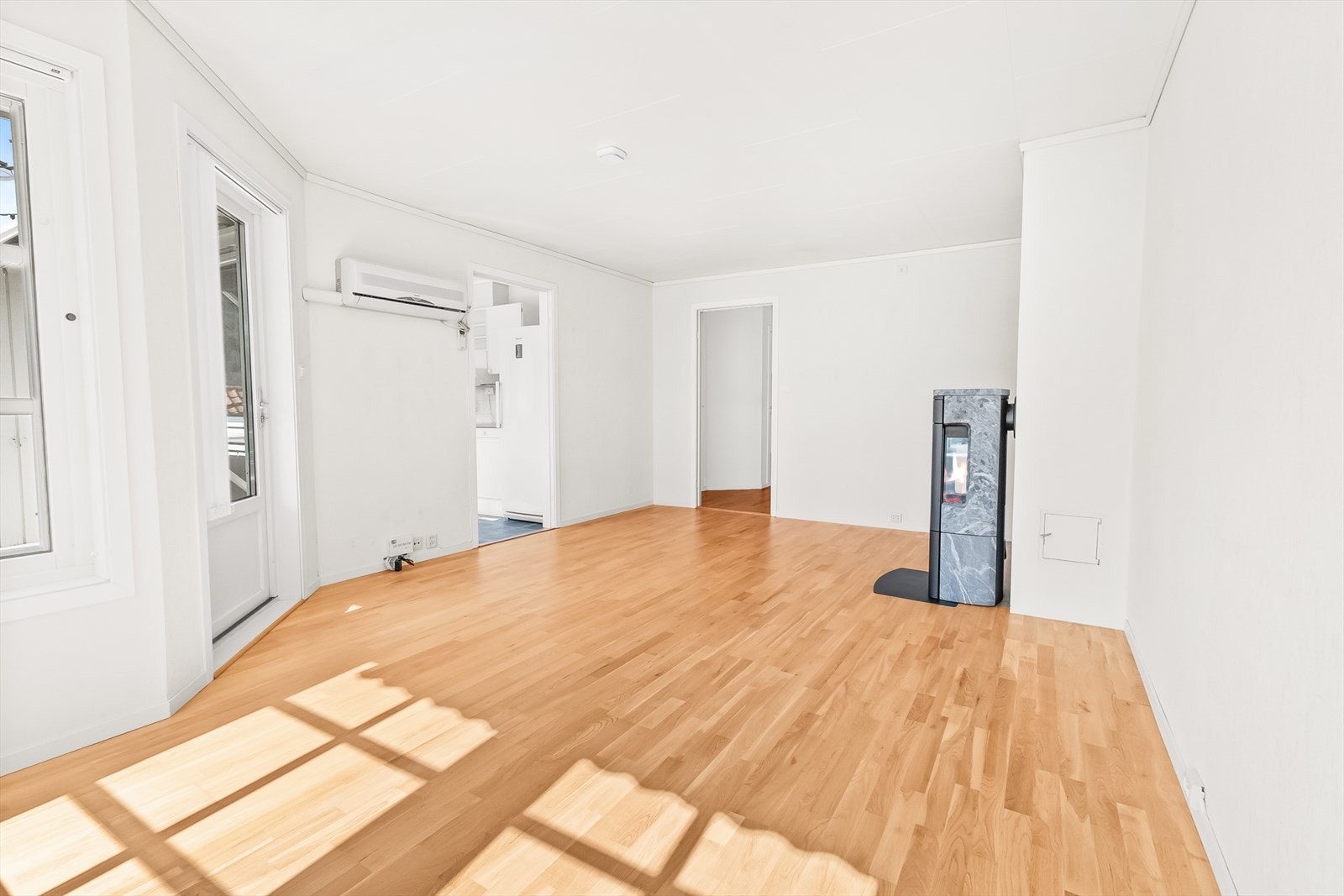 I stue er det både vedovn og varmepumpe til oppvarming. Galleribilde