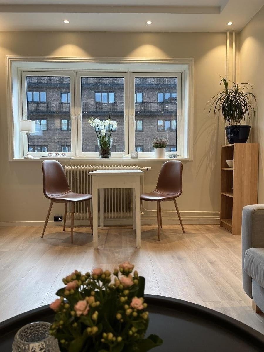 Stue/kjøkken-løsning med god takhøyde og plass til både sofa og spisebord Galleribilde