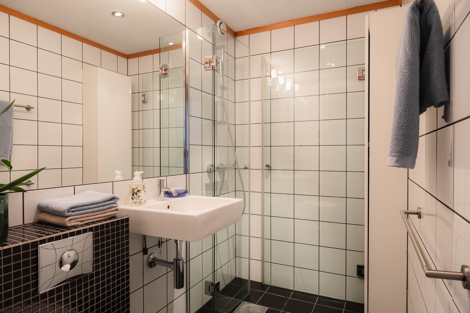 Baderom fra ca. 2005 med gulvvarme, dusjhjørne med innfellbare dører, servant og vegghengt toalett. Galleribilde