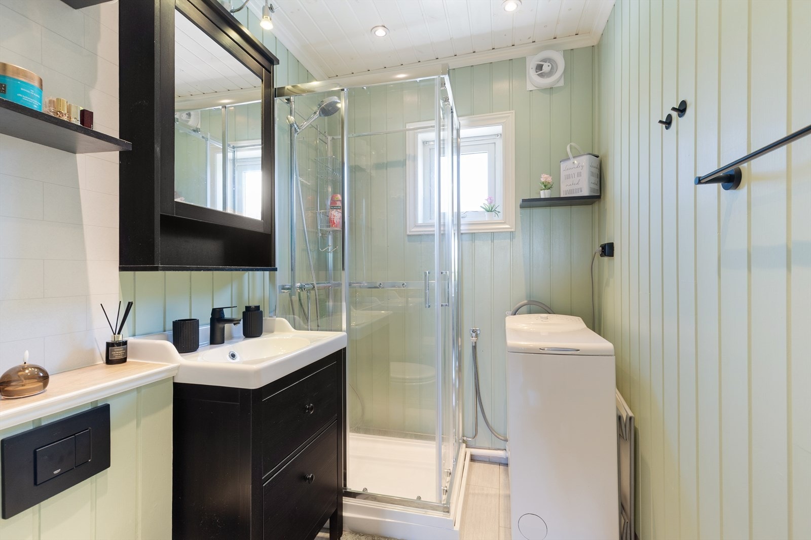 Badet har flislagt gulv med varmekabler, vegghengt toalett og opplegg for vaskemaskin. Galleribilde