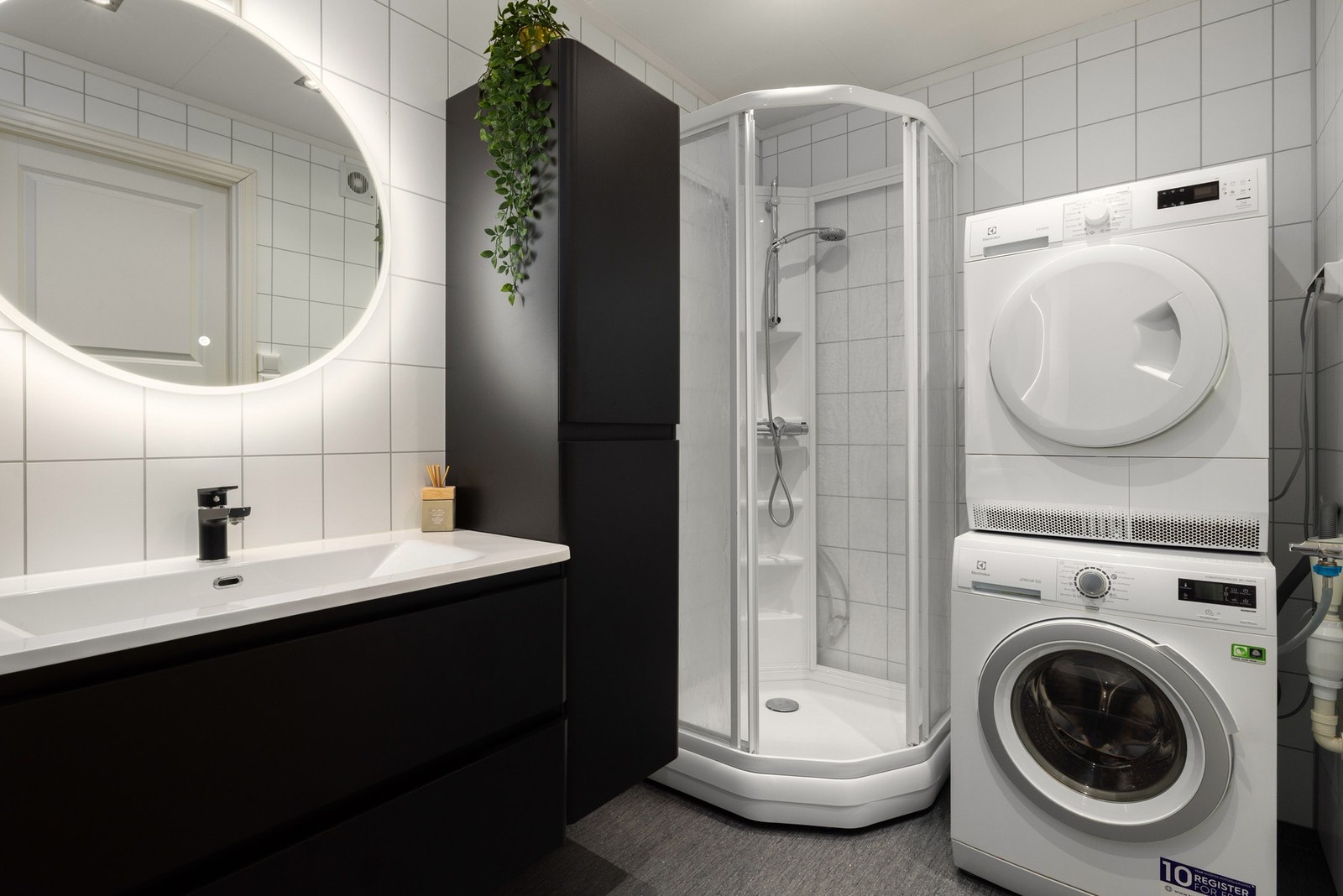 Badet fremstår som moderne og delikat, innredet med servant, speil, dusjkabinett og opplegg for vaskemaskin. Galleribilde