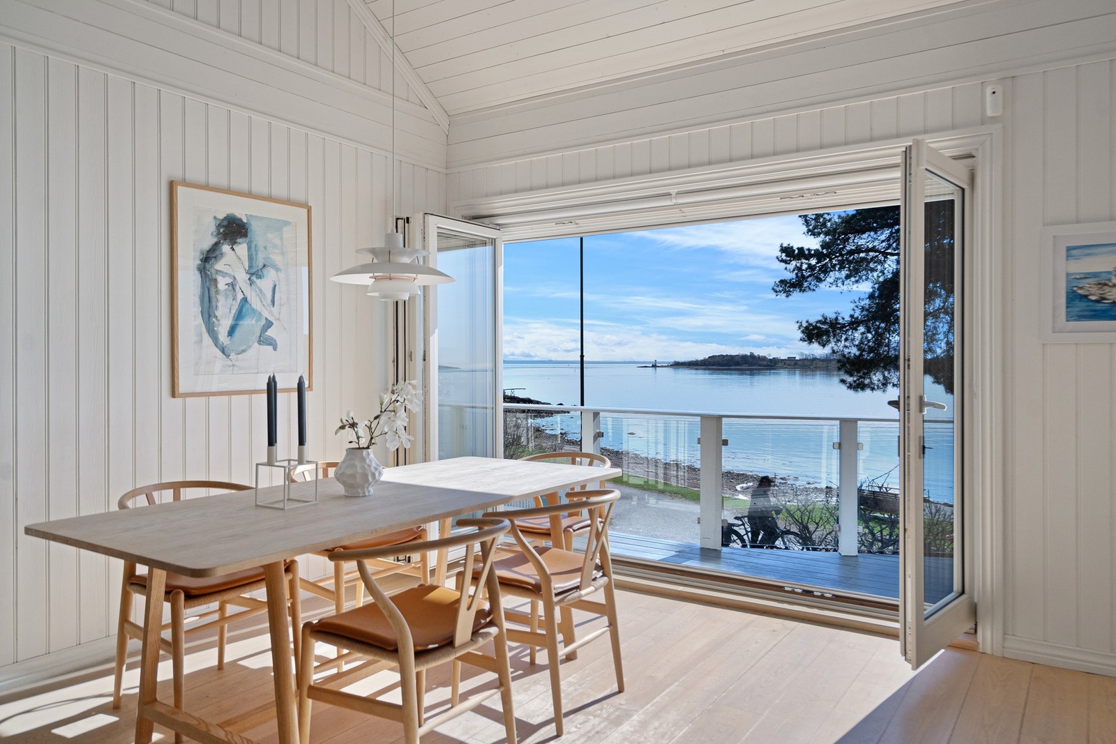 Foldedører som tar sjøen inn i stuen Galleribilde