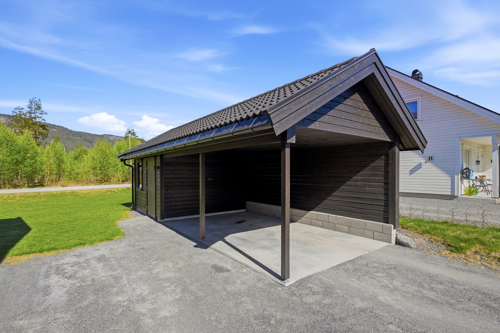 Frittstående carport med bod, oppført i samme stil som boligen. Galleribilde
