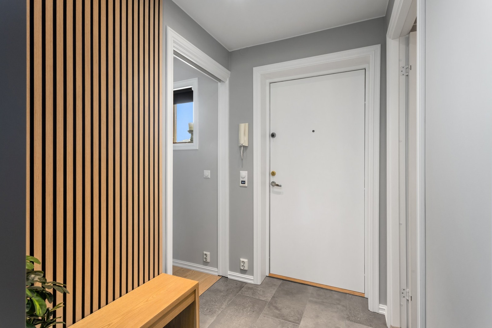 Innbydende gang med moderne uttrykk, fliser på gulv og komfortable varmekabler. Galleribilde