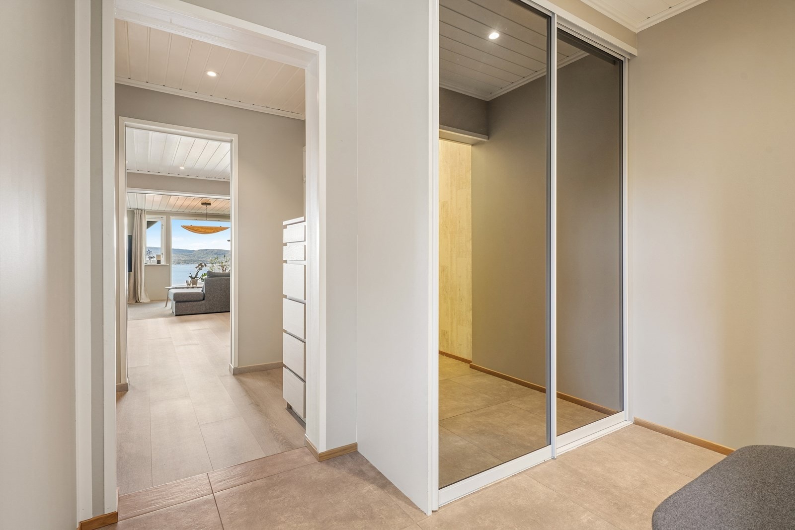 Fra entréen med skyvedørsgarderobe trekkes blikket umiddelbart mot stuen og den storslåtte fjordutsikten. Galleribilde