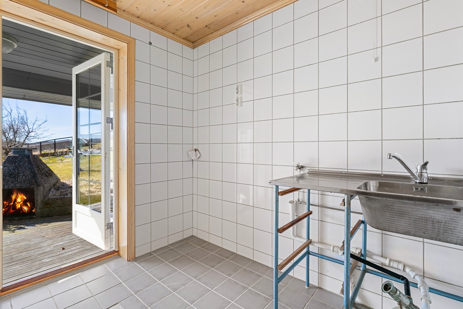 Separat vaskerom med fliser på gulv og vegger, utslagsvask og opplegg for vaskemaskin. Galleribilde