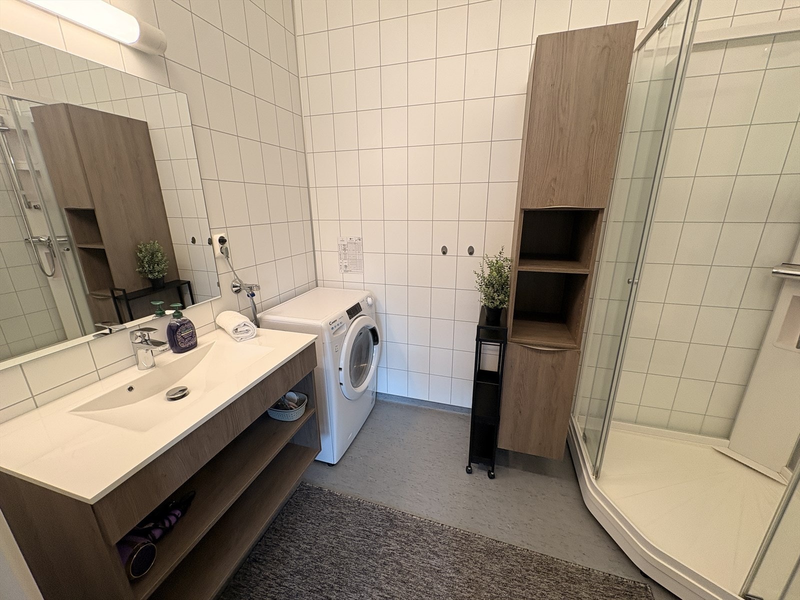 Baderom med ny servant og høyskap. Inneholder toalett, dusjkabinett og opplegg til vaskemaskin. Galleribilde