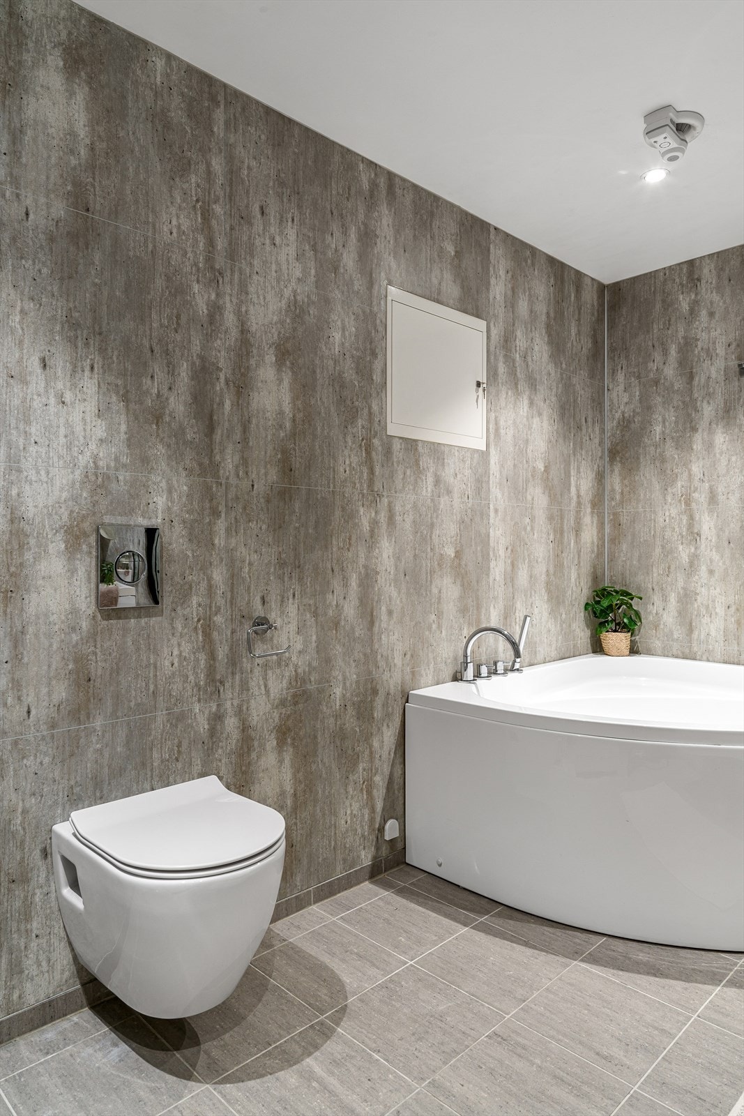 Badet er innredet med dusjhjørne, hjørnebadekar, vask i seksjon, vegghengt toalett og opplegg for vaskemaskin. Galleribilde
