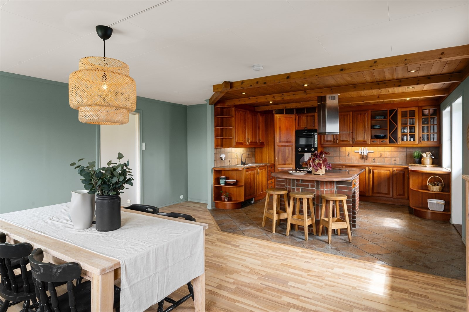 Kjøkkenet er i delvis åpen løsning mot spisestuen, med en praktisk kjøkkenøy som et sosialt midtpunkt. Galleribilde