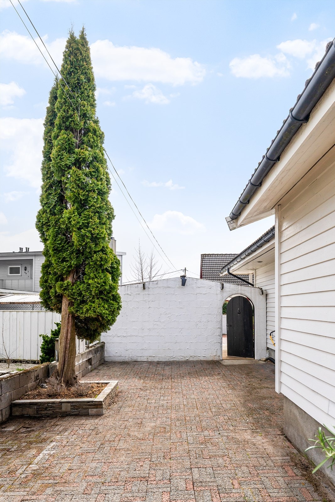 Gårdsplass med belegningsstein og adkomst til den overbygde uteplassen. Galleribilde