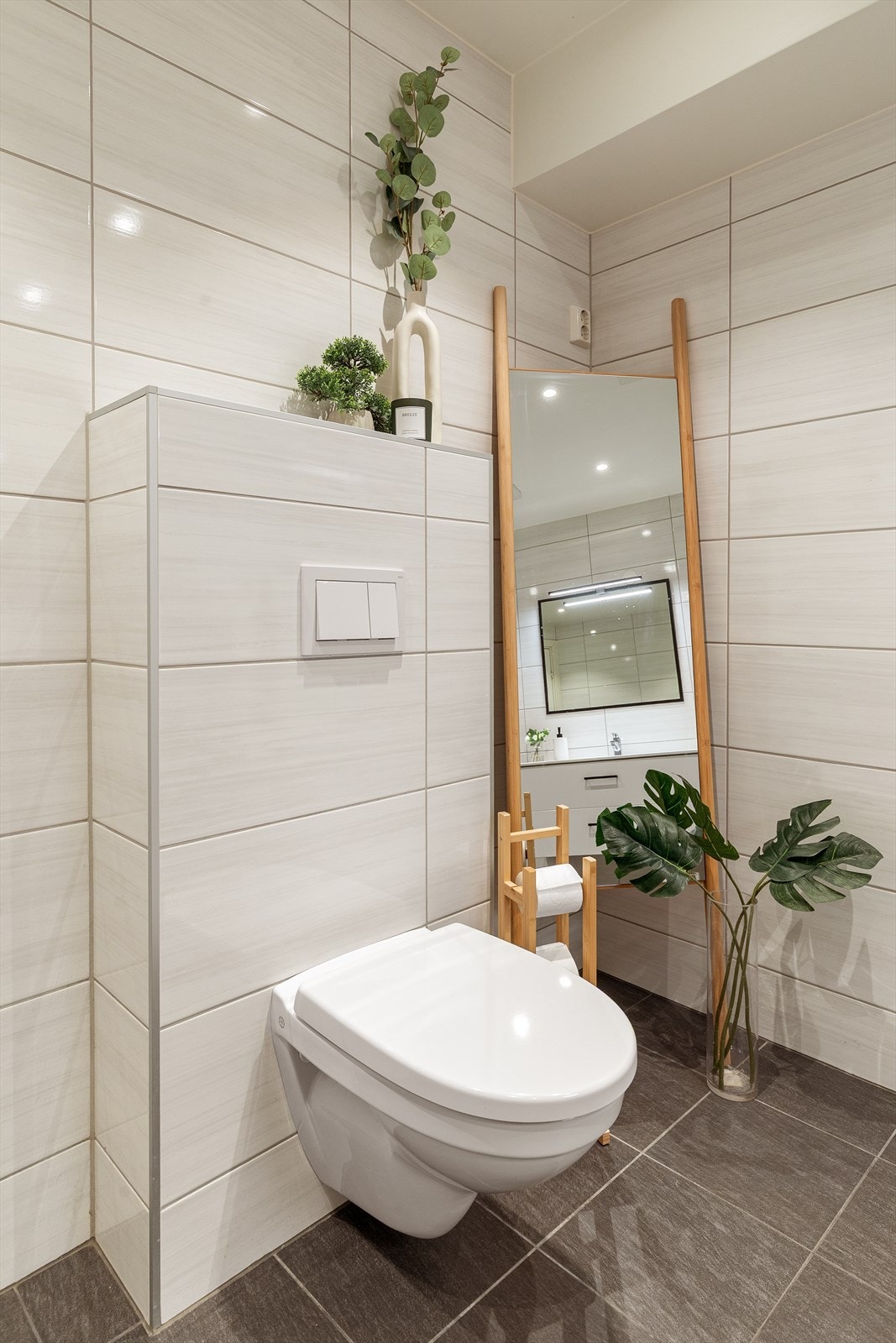 Videre er badet utstyrt med servant med underskap, speil, dusjnisje og toalett Galleribilde
