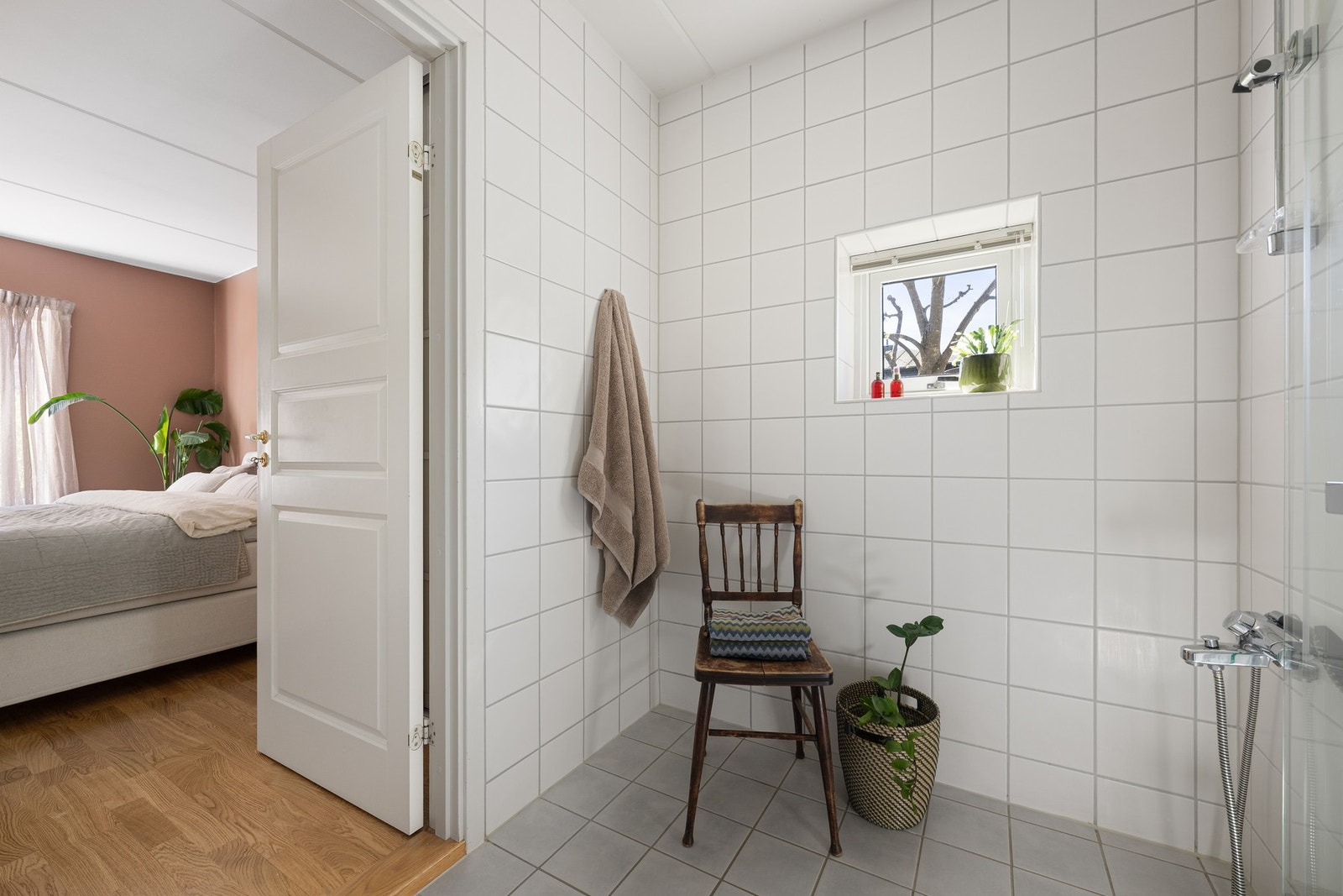 Badet har adkomst direkte fra hovedsoverommet og gir en praktisk og privat løsning i hverdagen. Rommet er flislagt og har dusjhjørne, servantinnredning, gulvmontert toalett og varmekabler i gulv. Galleribilde