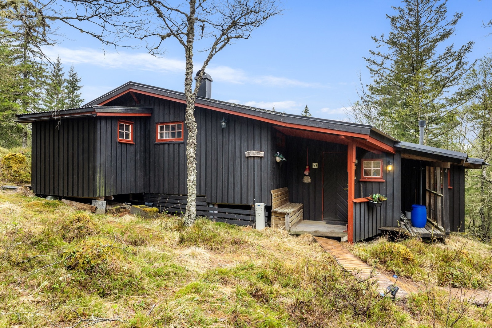 Hytta ligger pent integrert i naturen og det omkringliggende terrenget Galleribilde