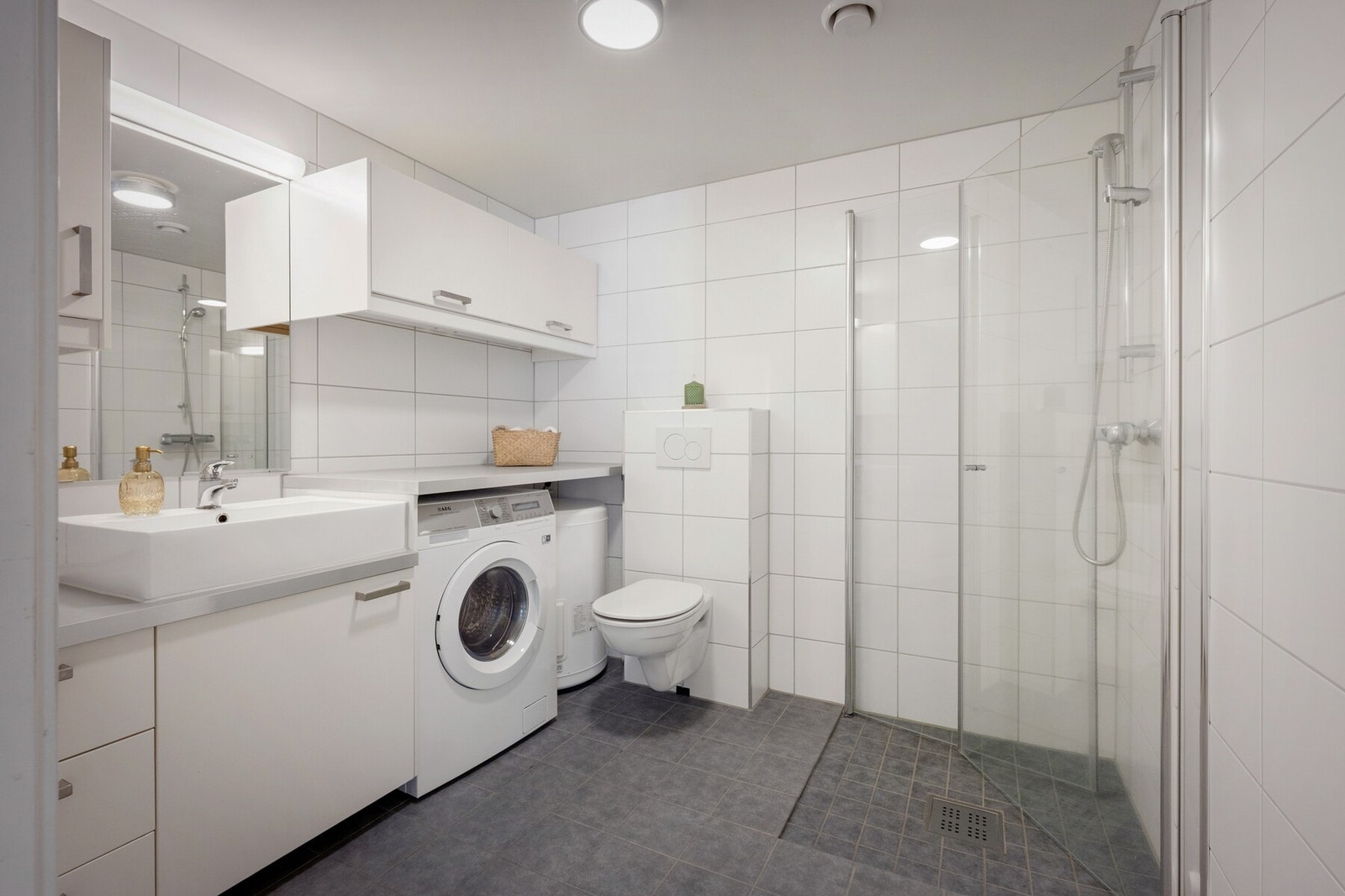 .Romslig bad med moderne uttrykk og praktisk innredning. Badet er utstyrt med servant med gode oppbevaringsmuligheter, speilskap, toalett og dusjhjørne med glassvegger. Galleribilde