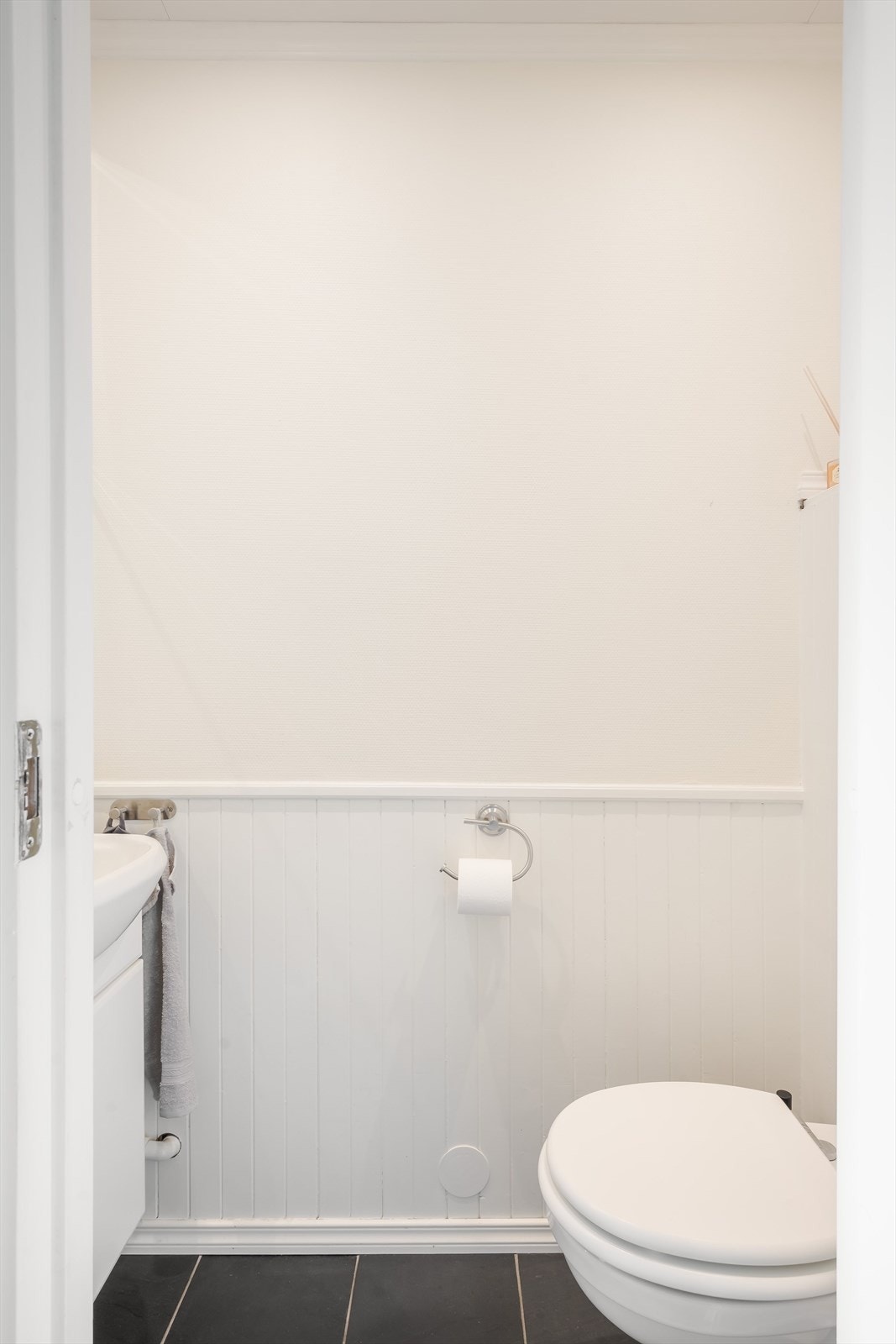 Vegg-i-vegg med baderommet er det et praktisk separat toalettrom med mørke fliser på gulv. Galleribilde