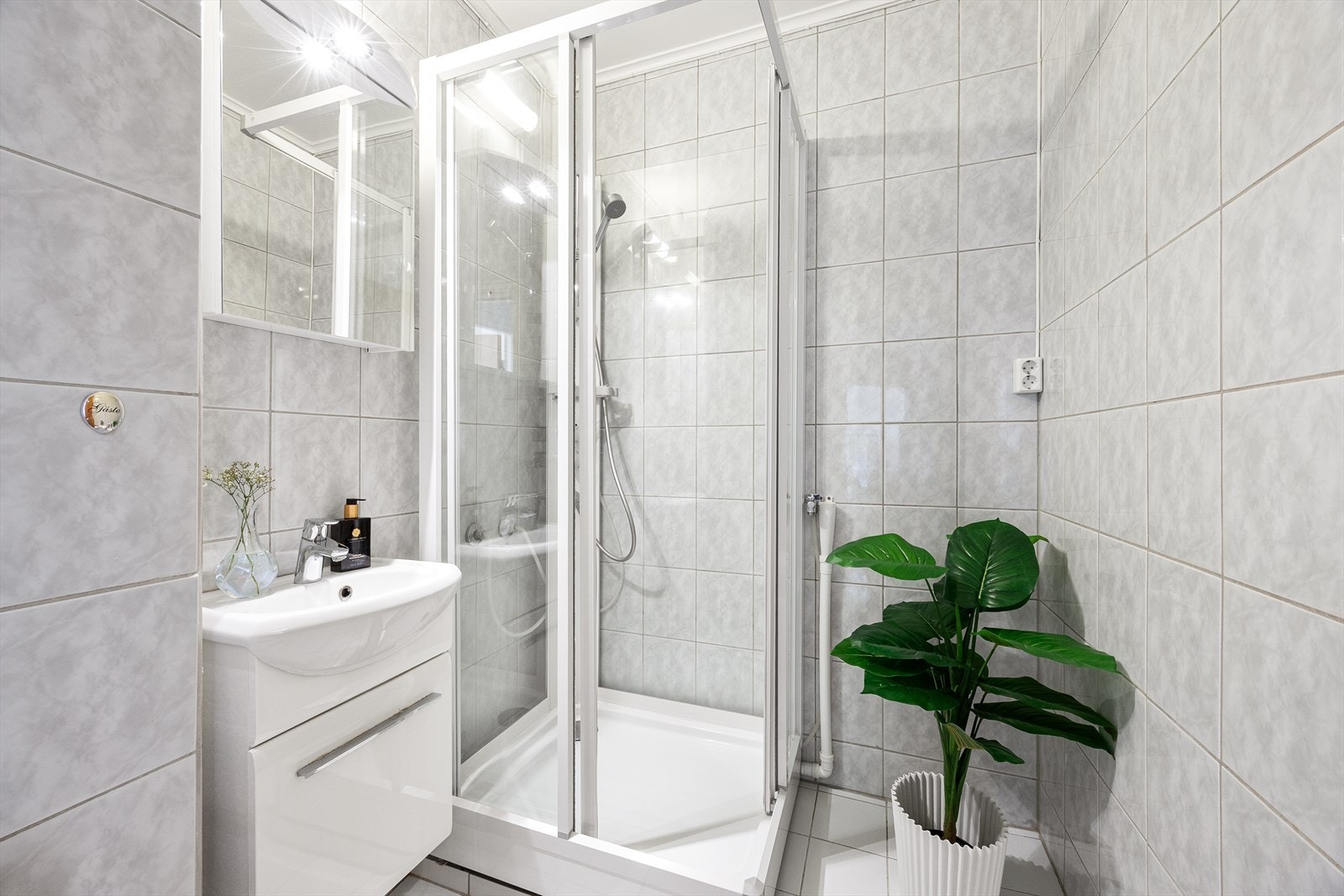 Det er plass for dusj, vask, toalett og en liten vaskemaskin på badet Galleribilde