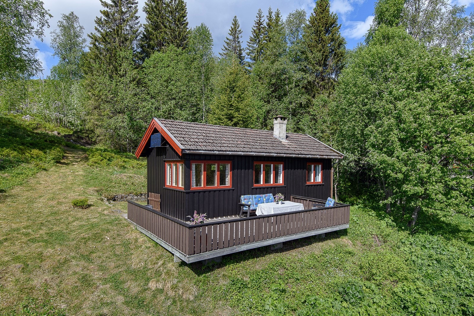 Koselig, eldre hytte med større veranda. Bilde er gjenbruk fra salg i 2021, avvik kan forekomme. Galleribilde