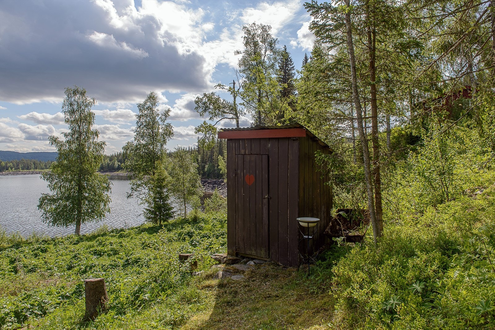 Utedoen er plassert usjenert på tomten, med utsikt mot vannet. Bilde er gjenbruk fra salg i 2021, avvik kan forekomme. Galleribilde