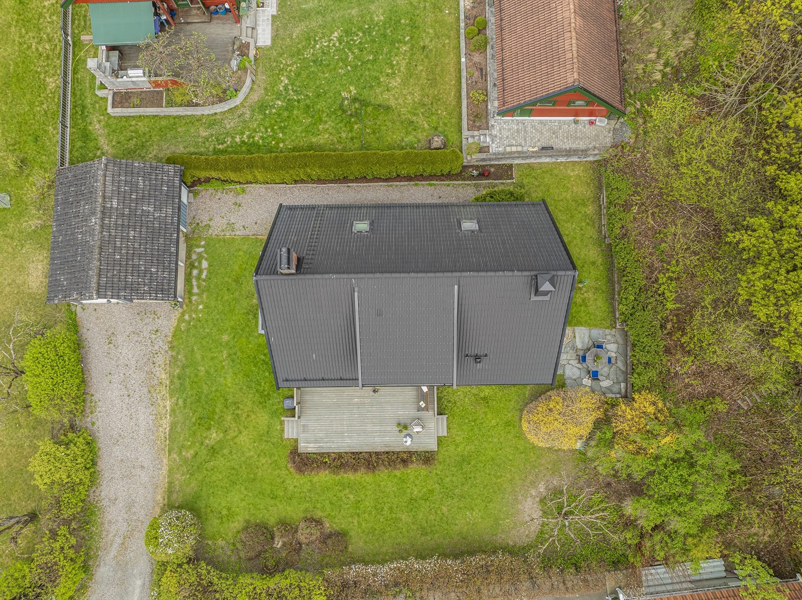 Tomten er pent opparbeidet med plen, hekk og gruset gårdsplass. Galleribilde