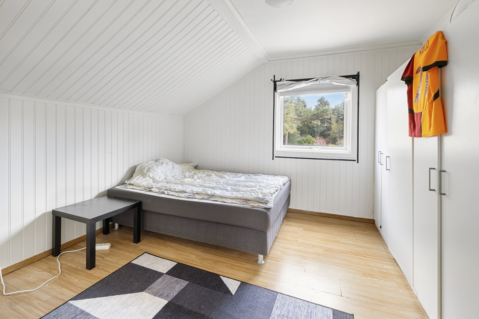 Et av to soverom i andre etasje. Rommet har laminatgulv og panel i taket. Galleribilde