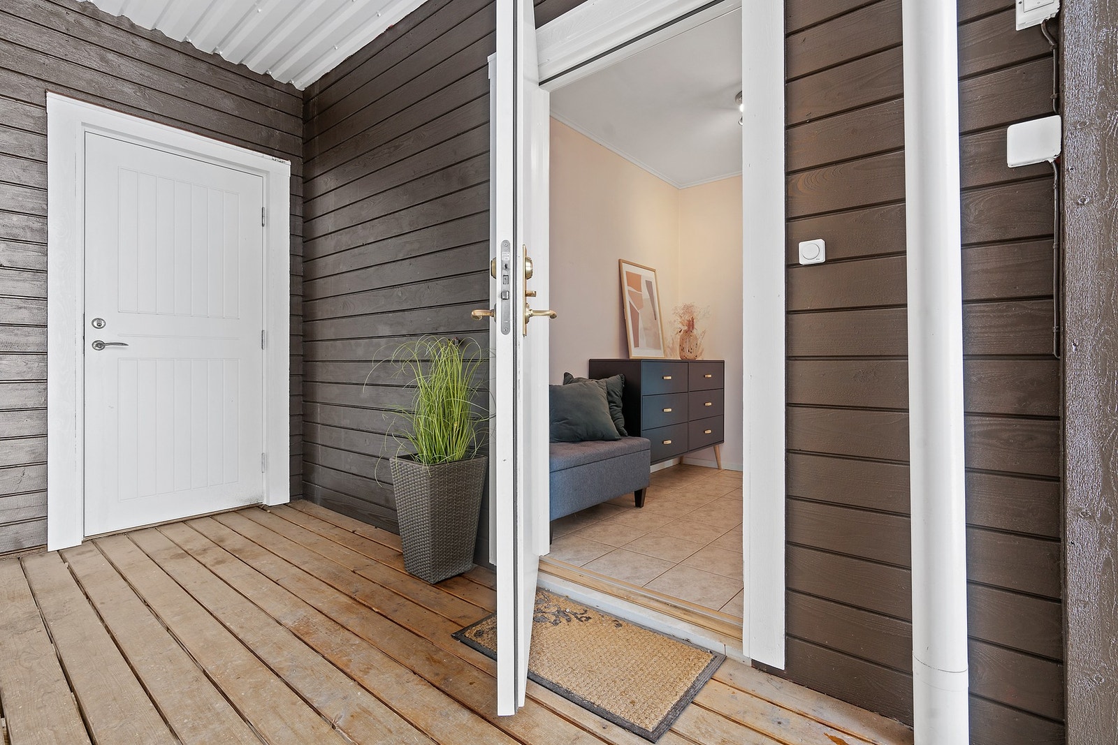 Overbygget inngangsparti med adkomst via utvendig trapp i impregnerte materialer. Galleribilde