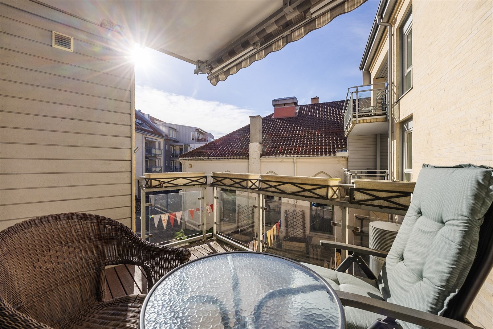 Balkongen har rekkverk i stål og glass, og impregnerte terrassebord. Det er montert elektrisk markise for solskjerming. Galleribilde