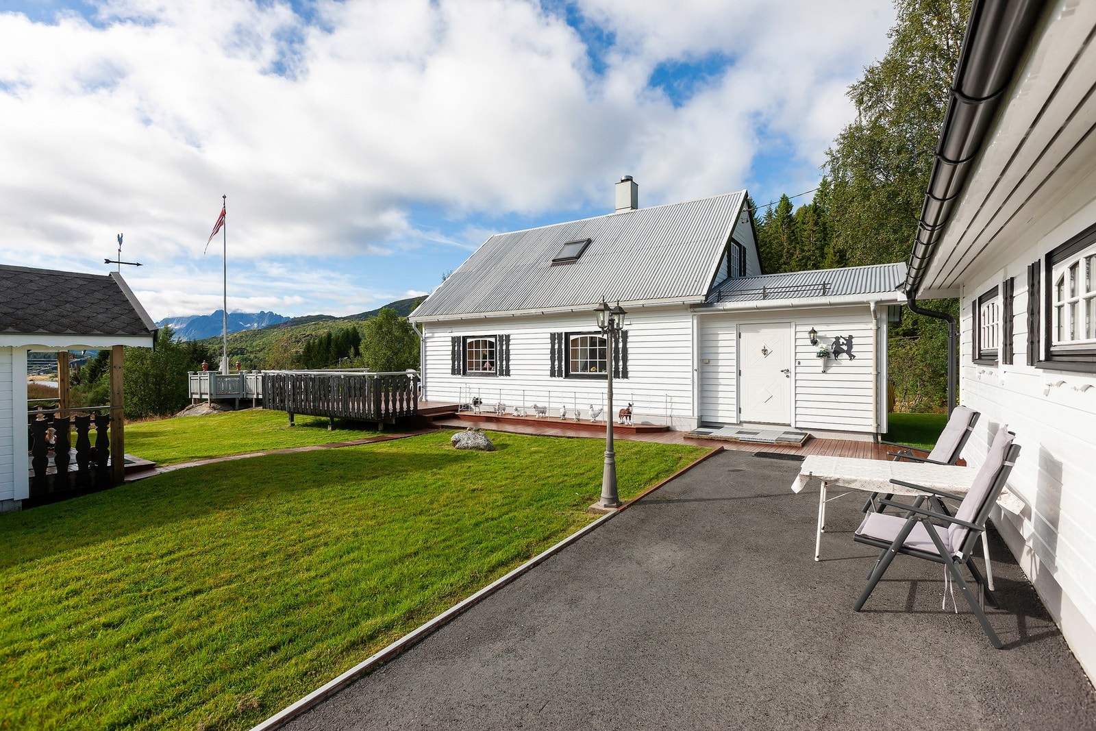 Opparbeidet tomt med flott uteområde, plen, beplantning, asfaltert adkomst og parkeringsområde. Galleribilde