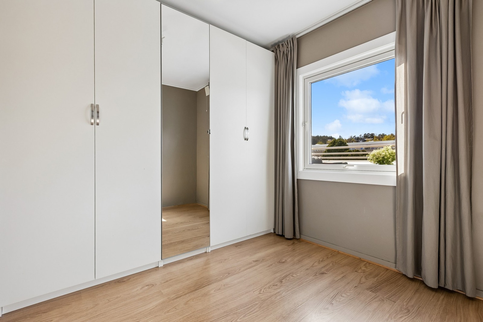 Her er det god plass og rikelig med oppbevaring - innebygd garderobe med speilfront gir soverommet et ryddig preg. Galleribilde