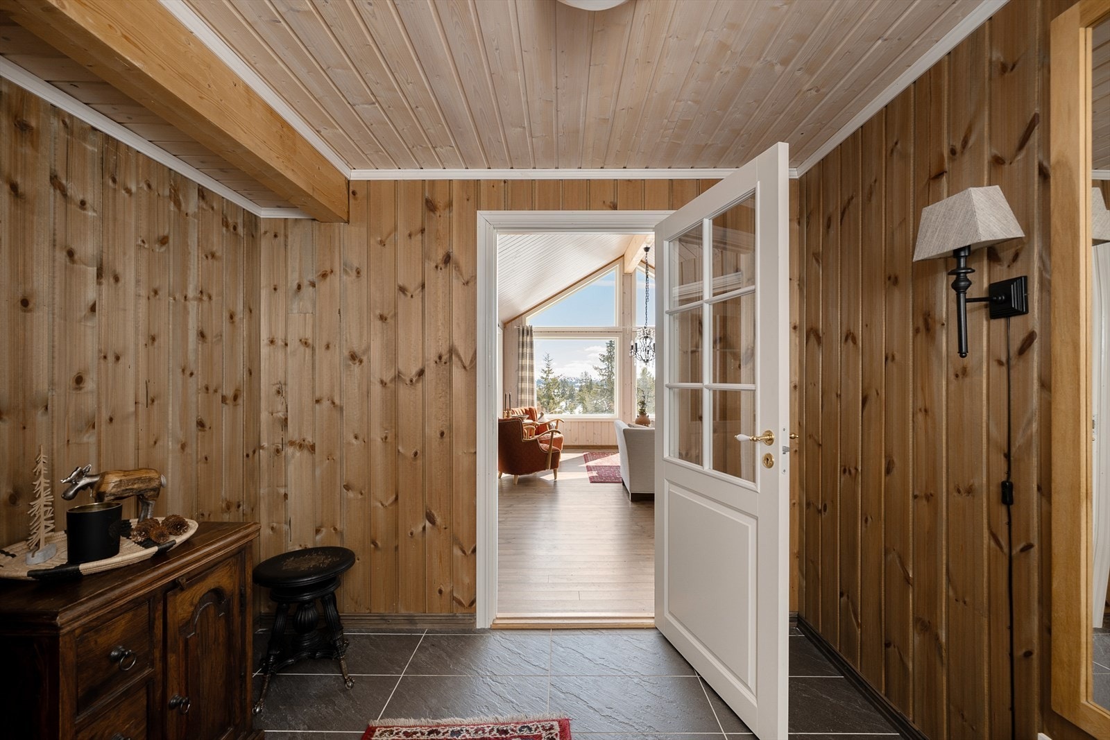 Fra entréen er det adkomst til hyttas hyggelige og luftige stue. Dør mellom entréen og stua. Galleribilde