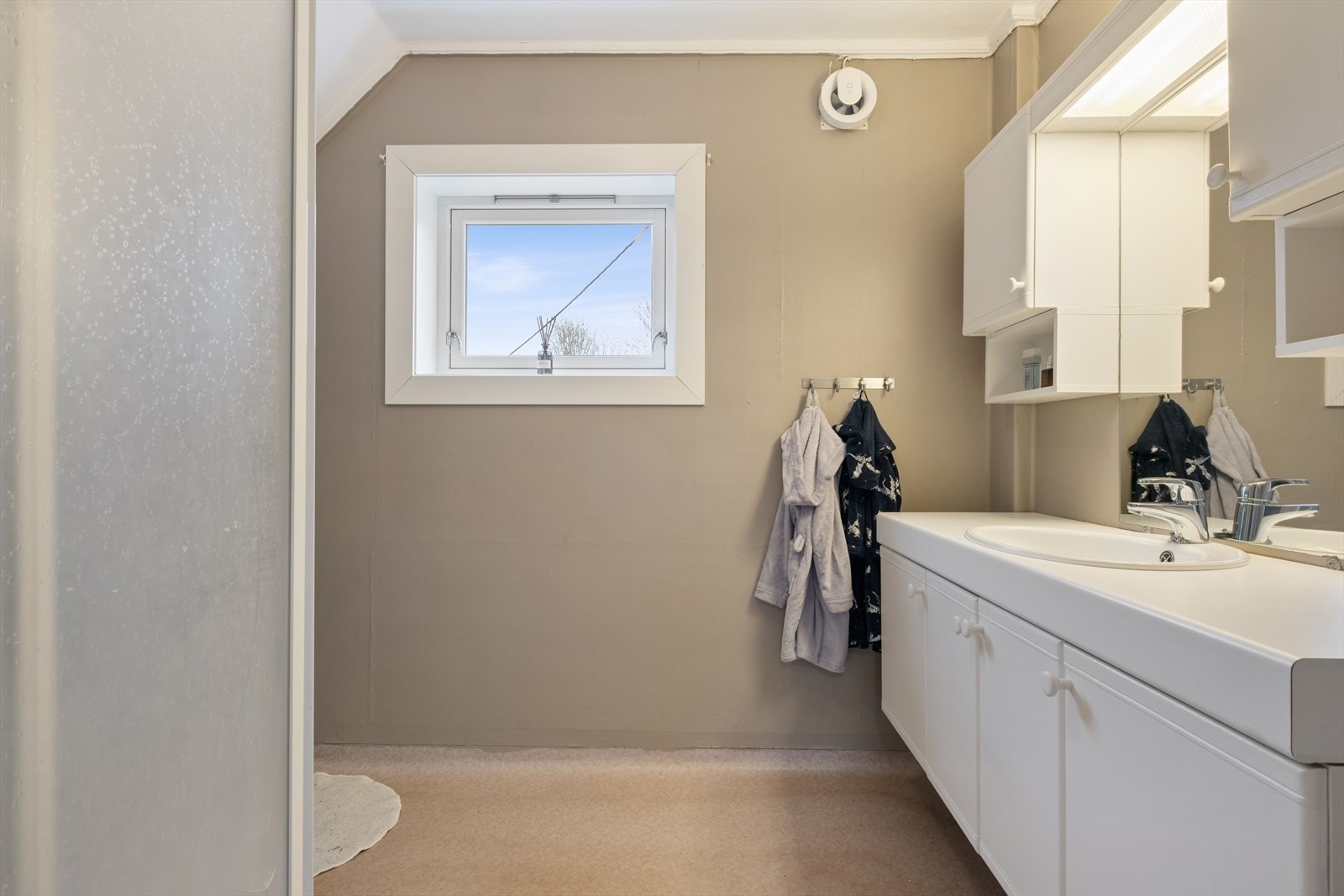 Badet på loftet er utstyrt med servantmøbel med god oppbevaringsplass og en dusjnisje. Galleribilde