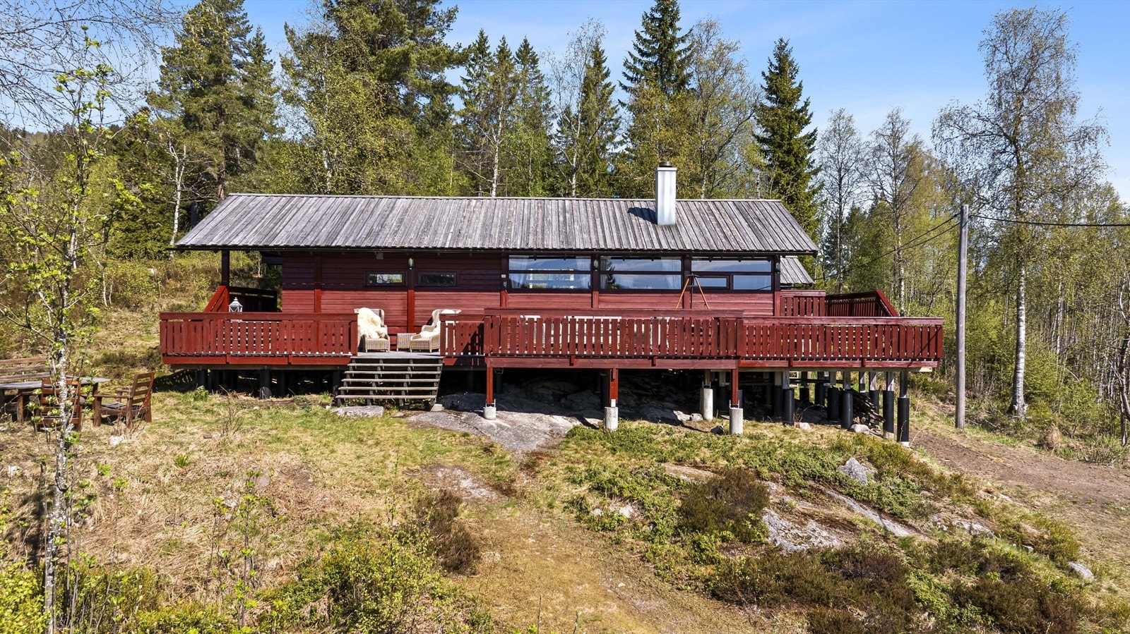 Hytta ligger på en stor og usjenert eiertomt på 2,3 mål. Den romslige terrassen på 92 m² omkranser hytta og gir rikelig med plass for uteliv. Foto: Maciej Krzysztof Galleribilde