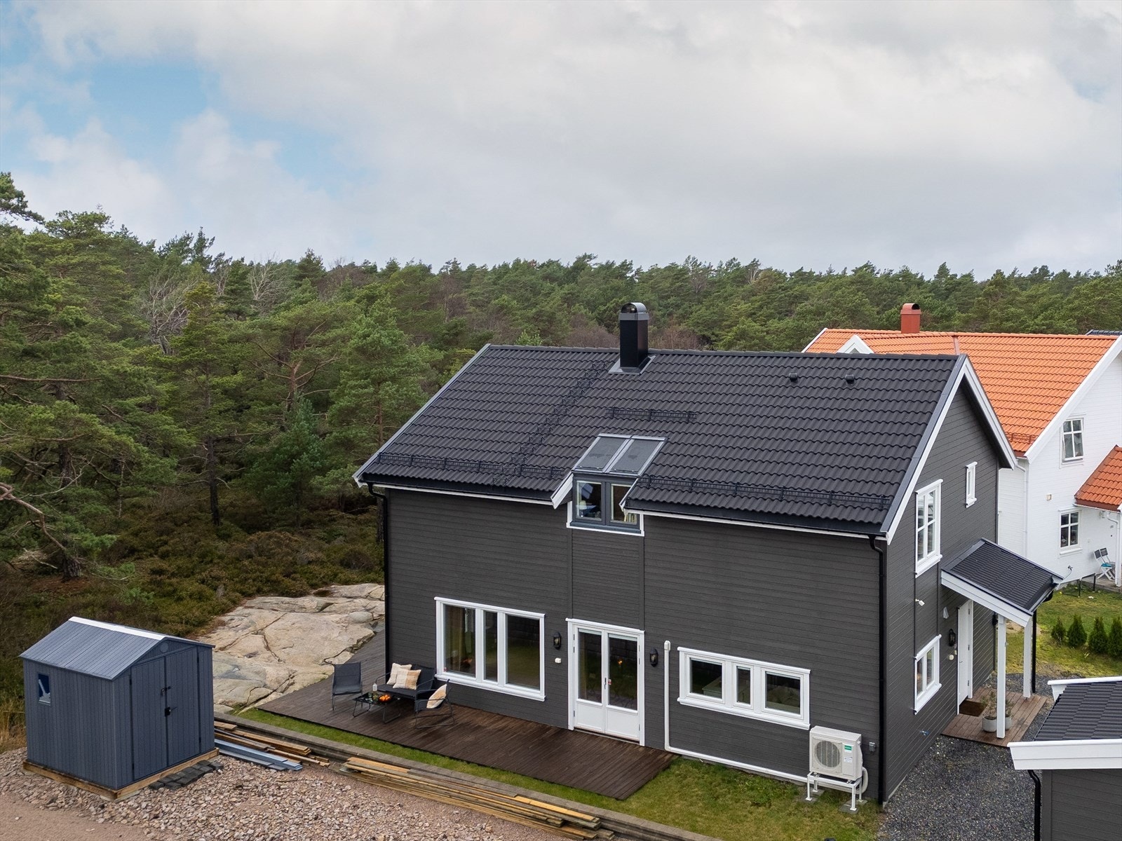 Boligen er over to etasjer med saltak og gråmalt kledning - tidløst men med noen moderne detaljer, så som de spennende takvinduene. Galleribilde