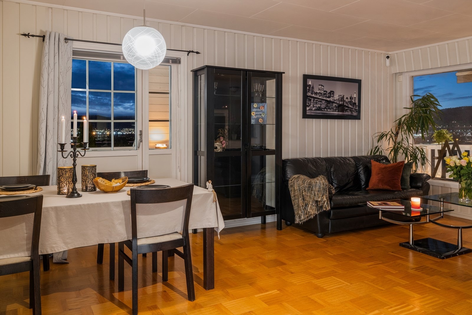 En stemningsfull ramme for måltider, med utsikt mot lysene fra nærområdet. Galleribilde