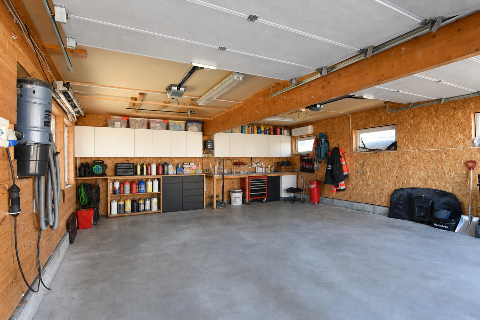 Romslig garasje med god plass til 2 biler. Garasjen har to leddporter, begge med portåpner. Garasjen er også utstyrt med varmepumpe og sentralstøvsuger(!) Galleribilde