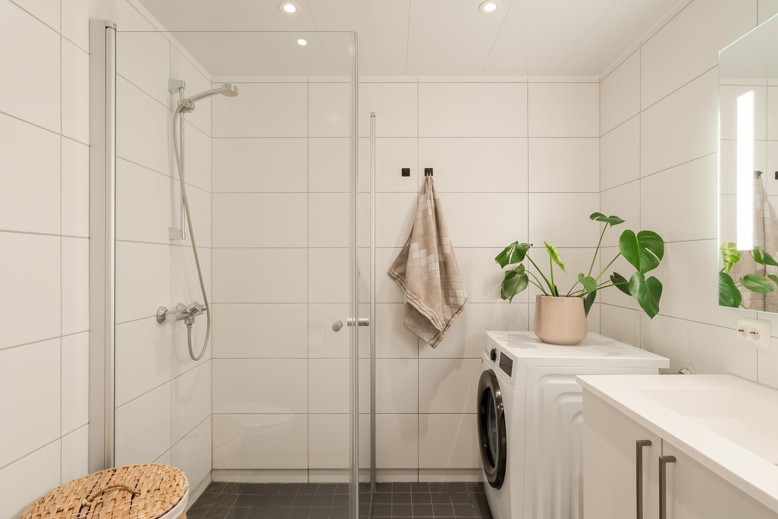 Badet har inngang fra kjøkkenet er på 4 kvm. Det har flis på gulv med varmekabler, flis på vegger og malt slett himling med downlights. Ingen tegn til fukt, i følge takstmann. Galleribilde