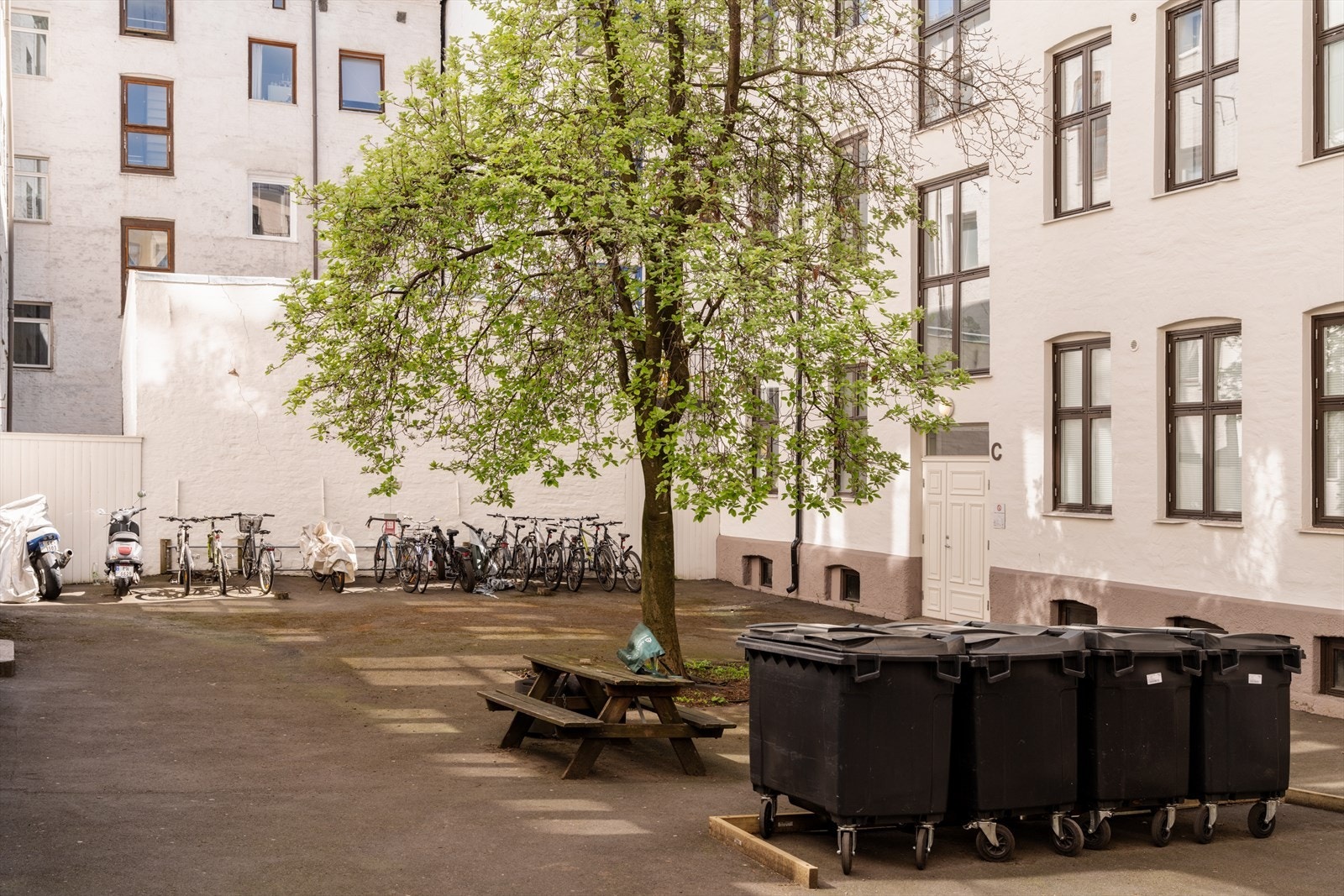 Skjermet bakgård med sittegrupper og sykkelparkering. Galleribilde