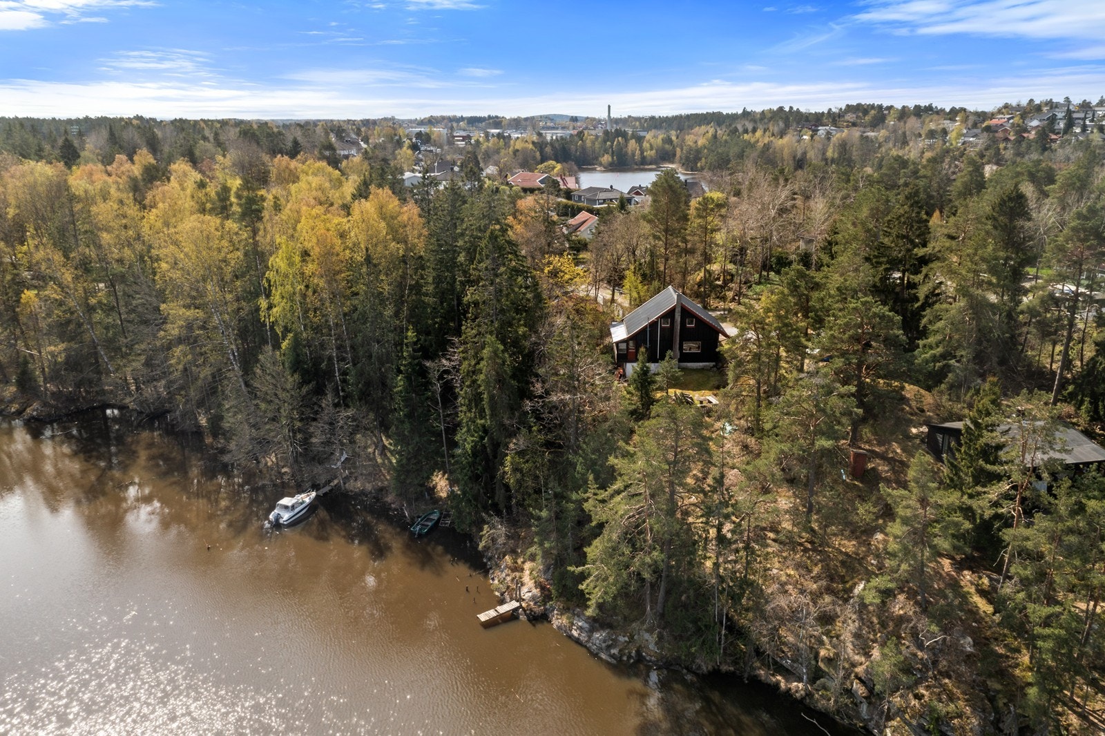 Tomten ligger høyt og fritt i terrenget med umiddelbar nærhet til skog og vann. Galleribilde