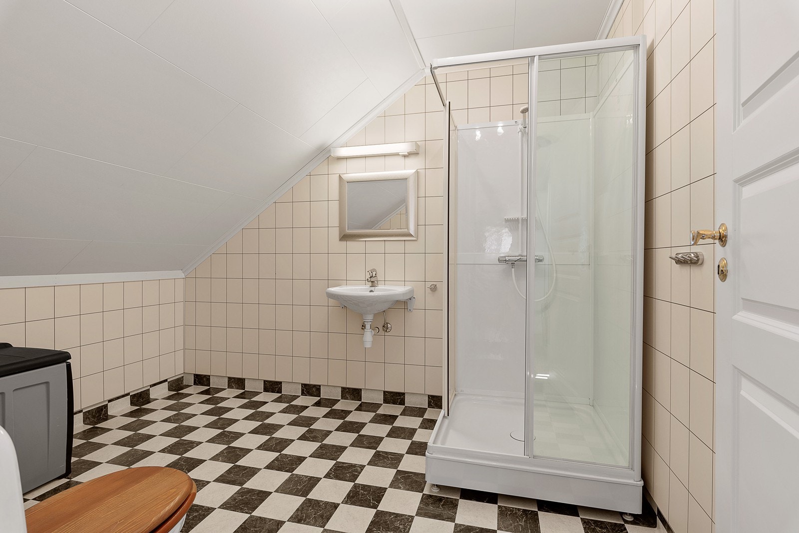 Badet i 2. etasje har lyse overflater og er innredet med dusjkabinett, servant med speil og toalett. Galleribilde
