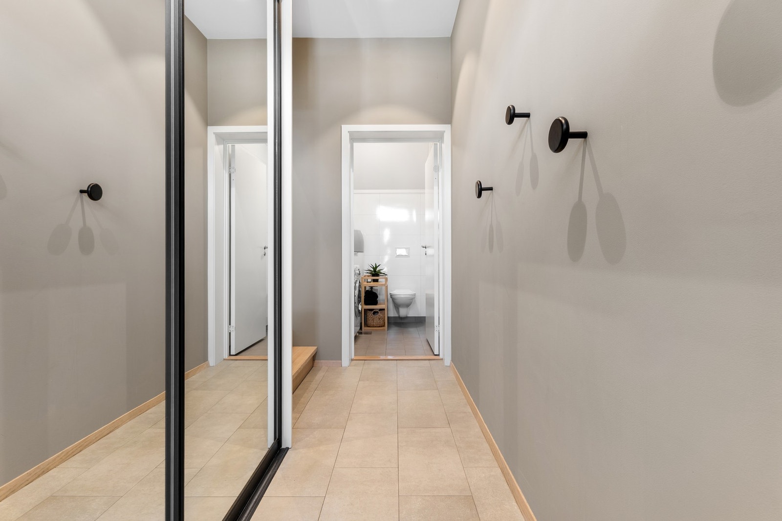 Flislagt entré med svært god takhøyde og mye lagringsplass i stor skyvedørsgarderobe. God plass til barnevogn, og svært praktisk med ekstra toalett på vaskerom i tilknytningen til entréen. Galleribilde