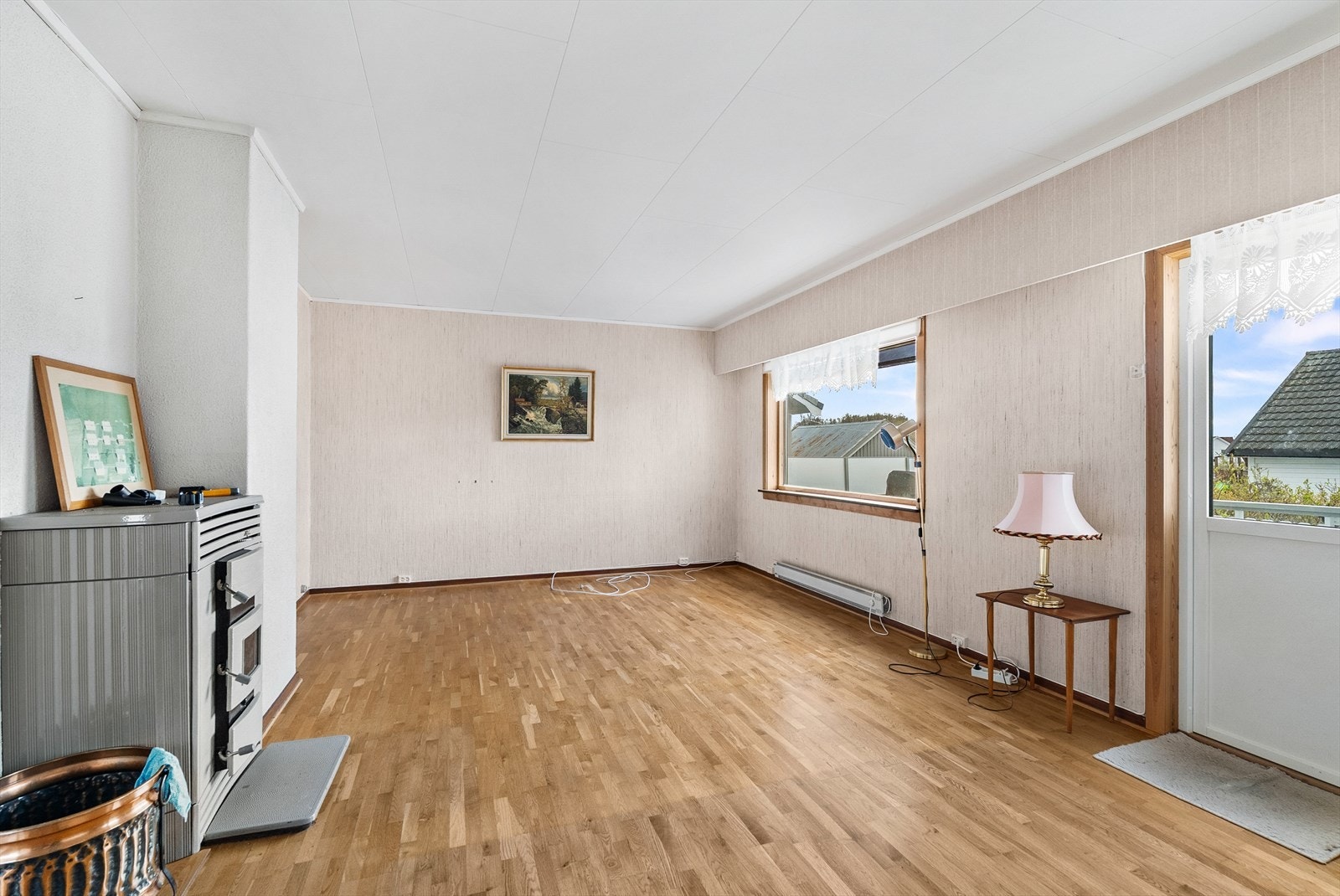 Stuen har parkett på gulv, vedfyrt ovn og direkte utgang til en stor terrasse. Galleribilde