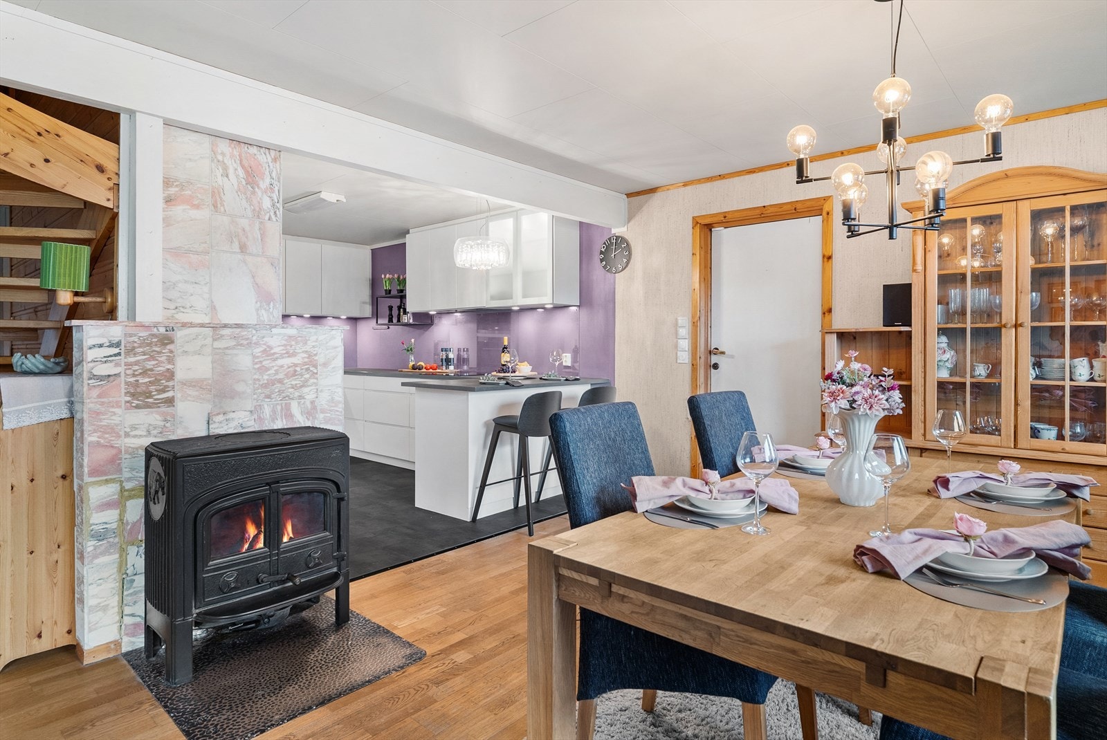 En vedfyrt ovn er sentralt plassert mellom kjøkken og stue, og bidrar til både varme og hygge. Galleribilde