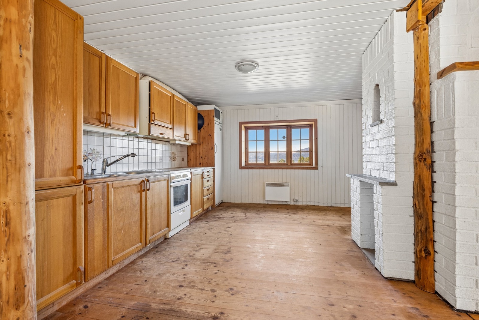 Kjøkkenet har en eldre innredning med profilerte fronter og benkeplate i heltre. Galleribilde