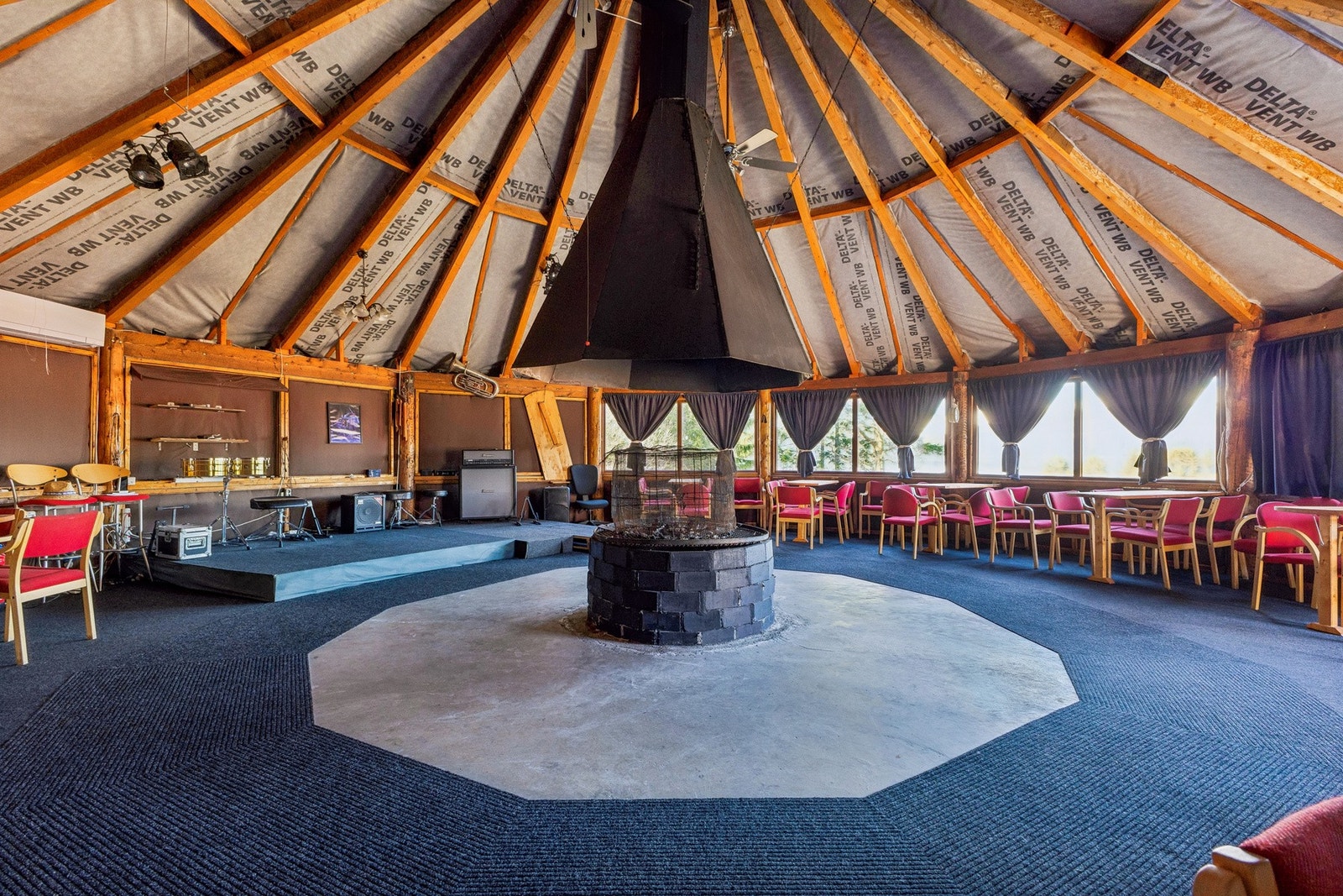 Inne i paviljongen er det et stort allrom med åpen himling og et ildsted i sentrum. Galleribilde