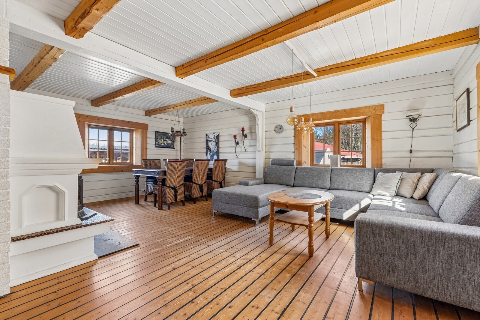 Den romslige stuen har god plass til både sofagruppe og spisebord. Veggene er av tømmer, som gir en lun atmosfære. Galleribilde